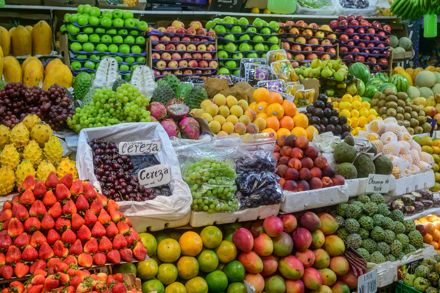 Market stall overflowing with colorful piles of fresh fruit.