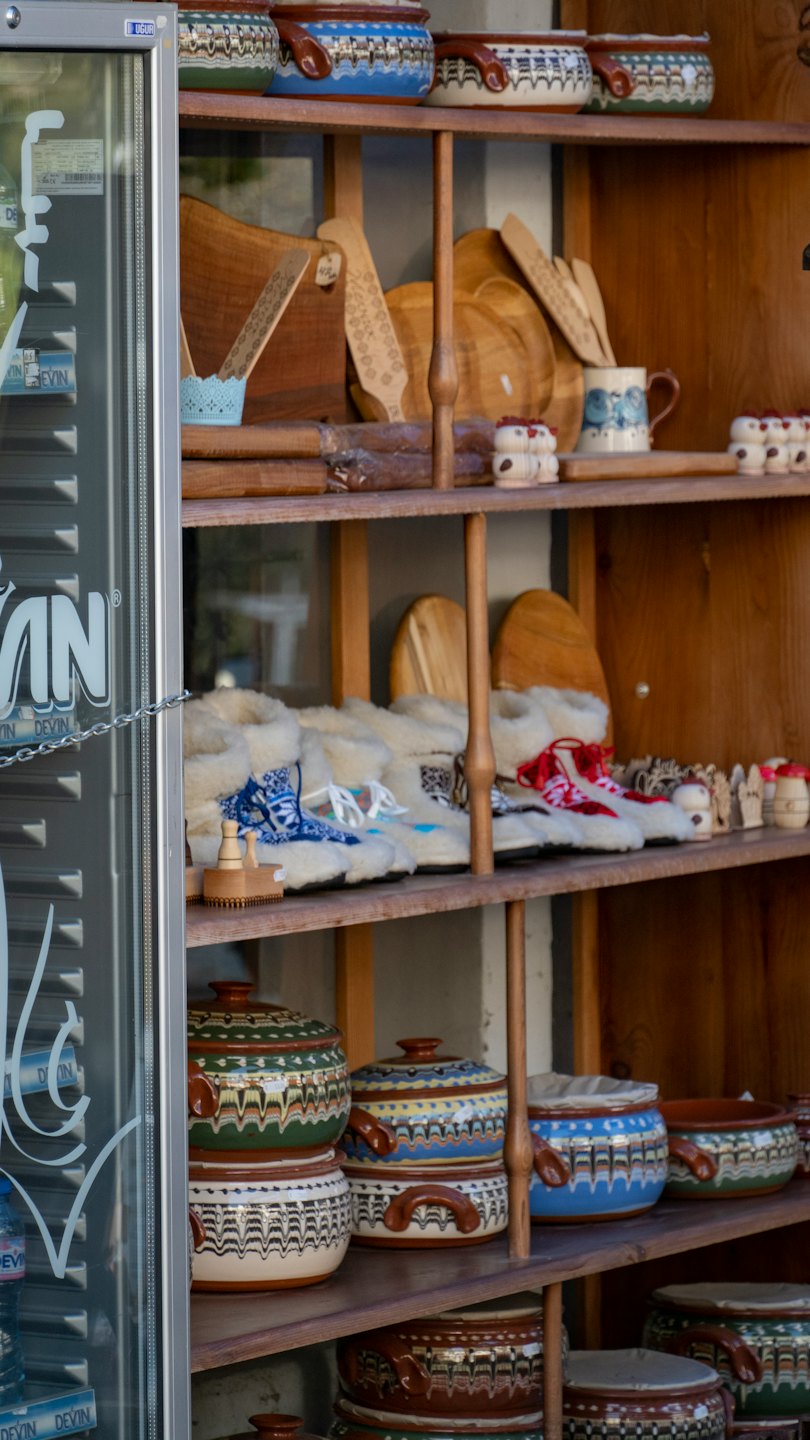 Handcrafted pottery and wooden items on rustic shelves.