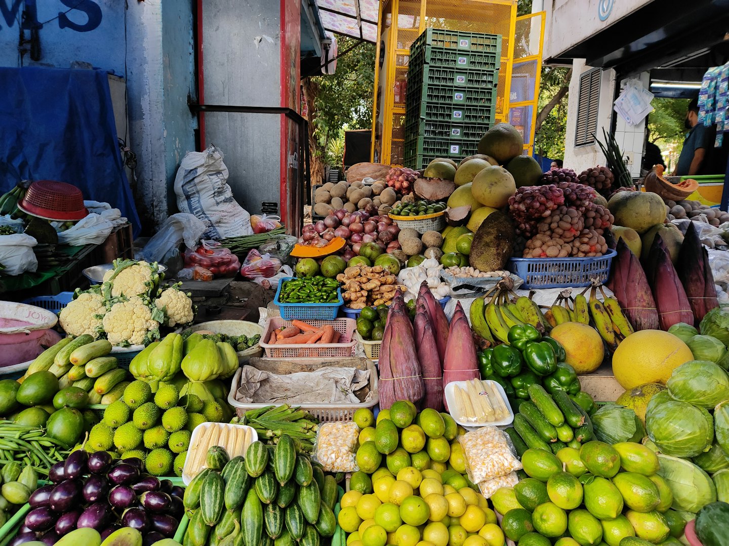Outdoor market stall piled high with colorful fresh fruits and vegetables.
