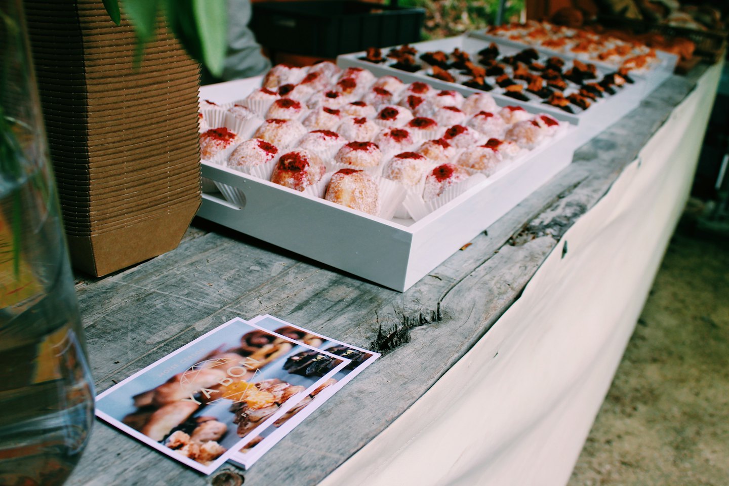 Pastries and promotional cards displayed on a wooden market stall.